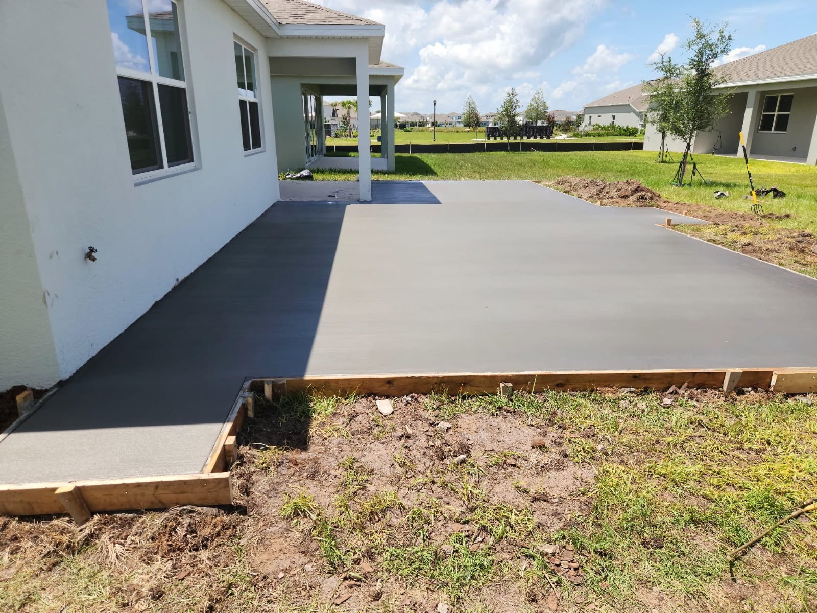 Freshly poured concrete patio and walkway with wooden forms