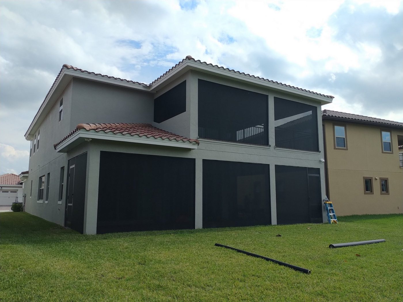 Two-story gray screen enclosure on a Florida home