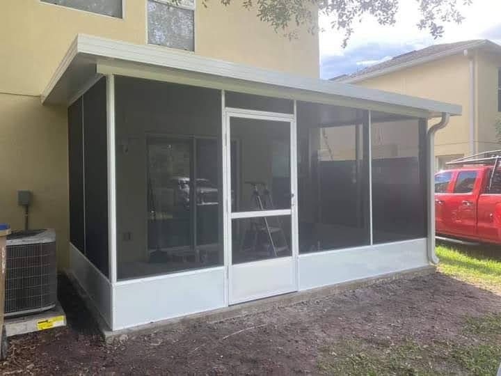 Compact white-framed screen room addition on a stucco home