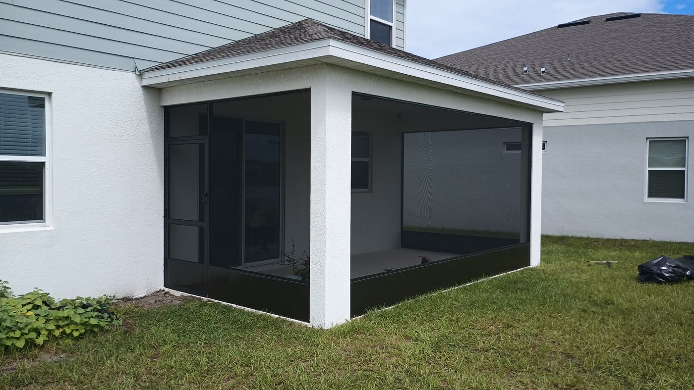White-framed screened lanai along the side of a Florida home