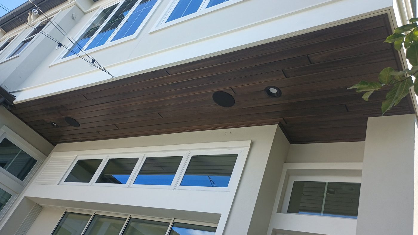 Exterior view of a porch with a dark wood tongue-and-groove ceiling