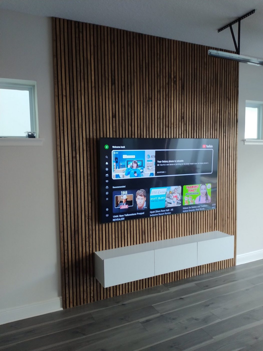 Vertical wood slat accent wall with a mounted TV