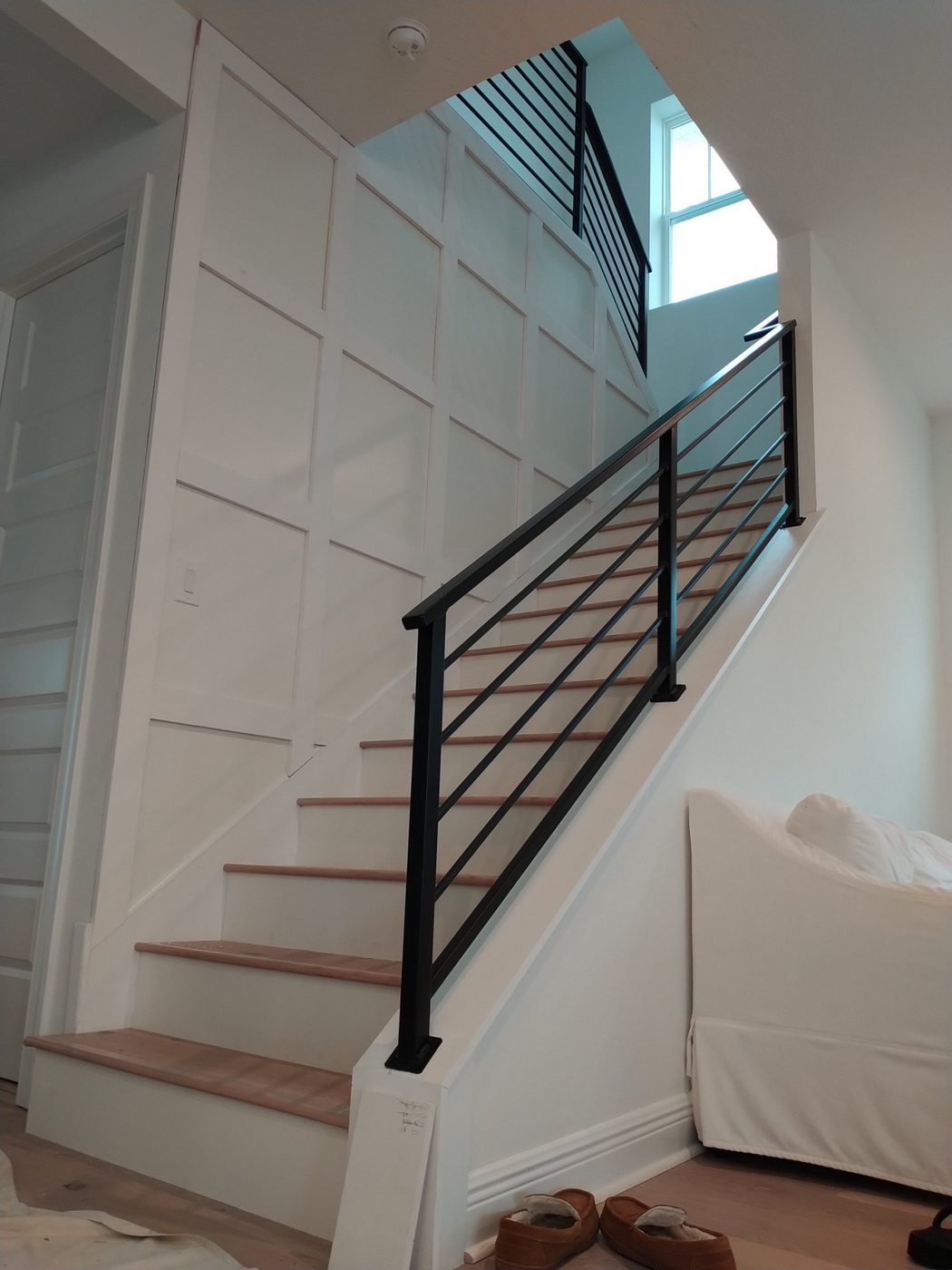Staircase with a white board-and-batten accent wall