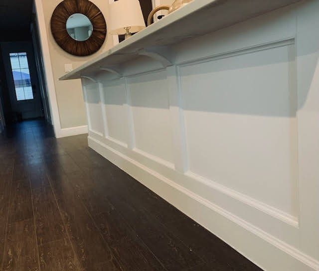 Entry half-wall with white shaker paneling