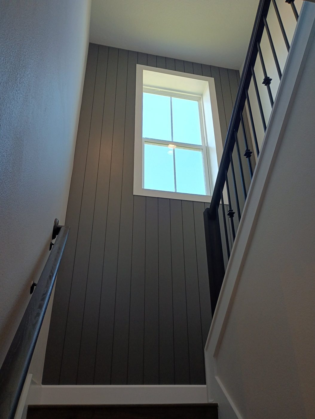 Stairwell with a vertical plank accent wall by the window