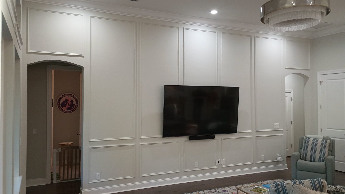 TV mounted on a white applied-molding panel wall