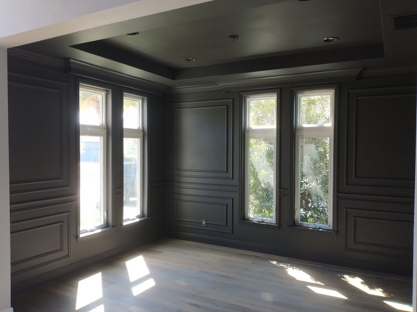 Home office with dark gray paneled walls