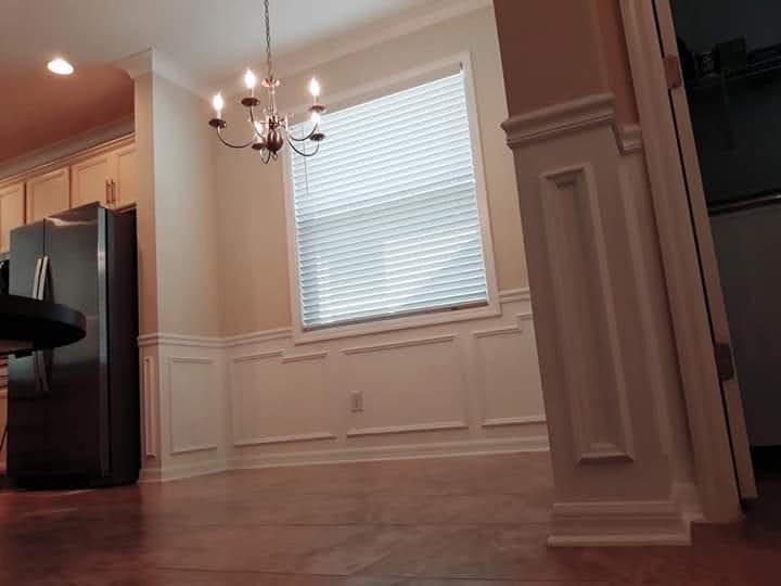 Dining area with wainscoting and trim columns