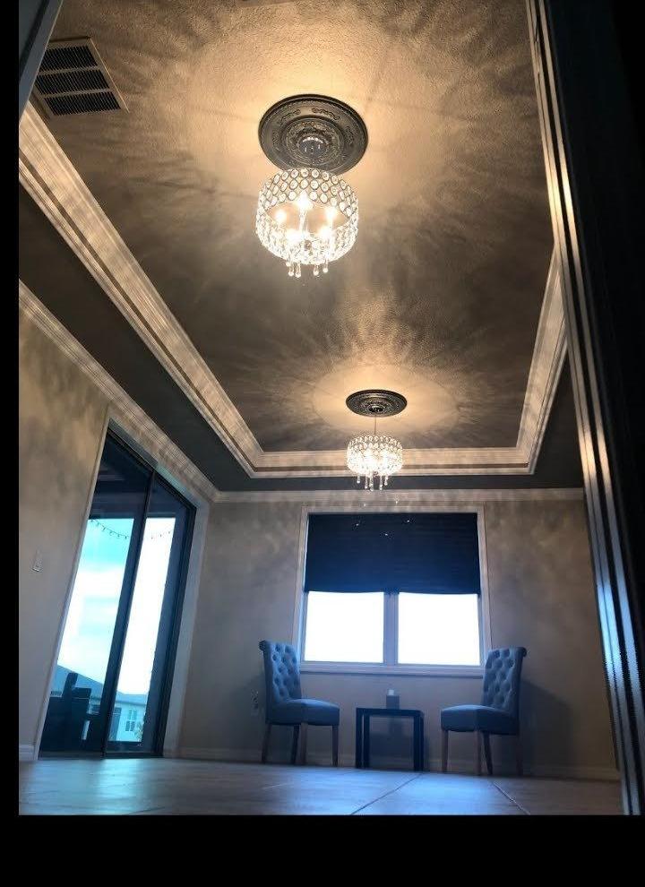 Tray ceiling with white crown molding and crystal chandeliers
