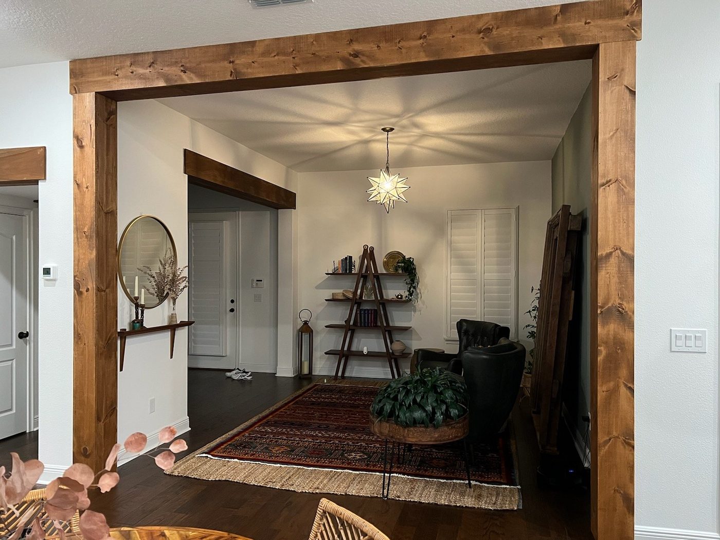 Rustic wood column wraps framing a living room opening