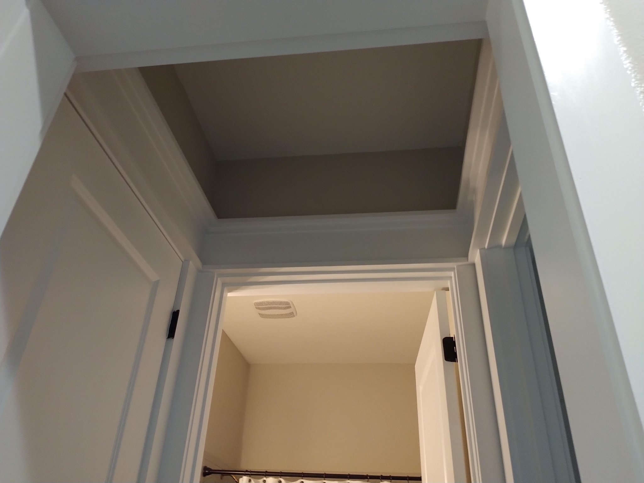 Crown molding and tray ceiling detail in a hallway