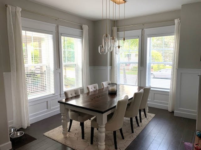 Dining room with white wainscoting and window trim under the windows